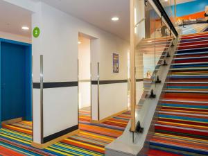 a staircase in a building with a colorful carpet at ibis Styles Budapest Citywest in Budapest +93 photos