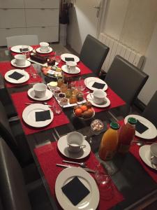 a table with red napkins and plates on it at Mes Oasis Nancy in Villers-lès-Nancy +16 photos