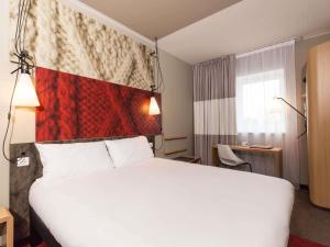 a hotel room with a white bed and a window at ibis Vilnius Centre in Vilnius