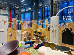a room with a child playing in a wooden play area at ibis Vilnius Centre in Vilnius