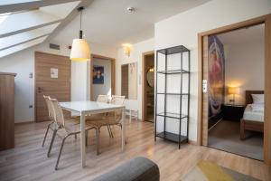 a dining room with a table and chairs and a bedroom at Imola Udvarház Dessert Hotel in Eger
