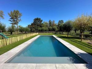 a swimming pool in a yard with a fence at Authentic rural square farm in Poperinge