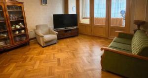 a living room with two chairs and a flat screen tv at Arman in Yerevan