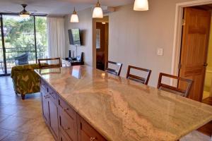 a kitchen with a large marble counter top and chairs at Pacific Shores B303 in Kihei