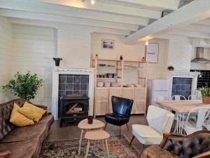 a living room with a fireplace and a table and chairs at Authentic rural square farm in Poperinge