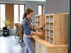 a woman is standing at a shelf in a store at ibis Styles Bamberg in Bamberg