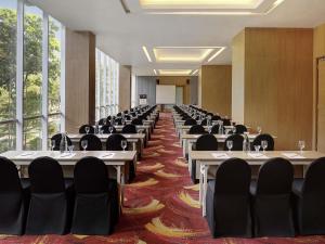 a conference room with tables and chairs and large windows at Mercure Bandung Nexa Supratman in Bandung +68 photos