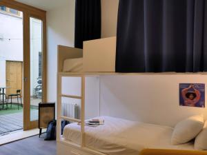 a bedroom with a bunk bed and a balcony at SLO Hostel Lyon Saxe in Lyon
