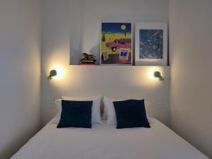 a bedroom with a white bed with two blue pillows at SLO Hostel Lyon Saxe in Lyon