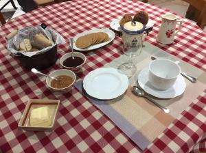 a table with plates of food on a red and white table cloth at Une nuit près de l'eau in Hallines +7 photos