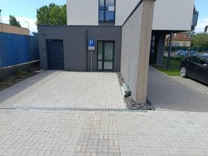 a parking lot in front of a building with a parking garage at Penzión Alma in Poprad