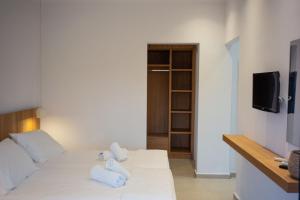 a room with a white bed with towels on it at Villa Prado in Almiros Beach +8 photos