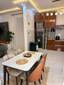 a kitchen and living room with a white table and chairs at Abban homes in Kampala