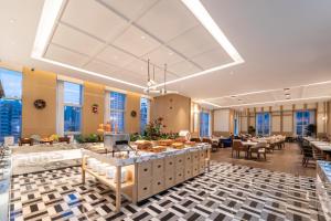 a lobby with tables and chairs in a building at Honder International Hotel in Guangzhou