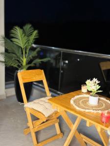 a wooden table and chair with a plant on a balcony at Abban homes in Kampala