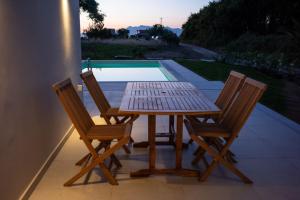 a wooden table and four chairs on a patio at Villa Prado in Almiros Beach