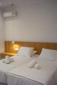 two beds in a room with two towels on them at Villa Prado in Almiros Beach