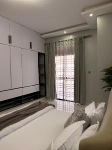 a bedroom with a large bed and a large window at Abban homes in Kampala