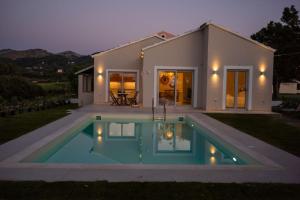 a house with a swimming pool in front of it at Villa Prado in Almiros Beach