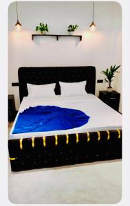 a bed with a blue blanket on top of it at Villa Lithu in Weligama