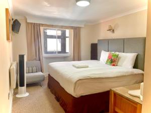 a hotel room with a large bed and a window at George Oxford Hotel in Oxford +18 photos