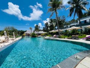 a swimming pool at a resort with palm trees at Apsara Resort Koh Rong in Koh Rong Island