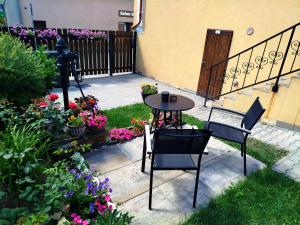 a patio with a table and chairs and flowers at Apartmán Kácov in Kácov