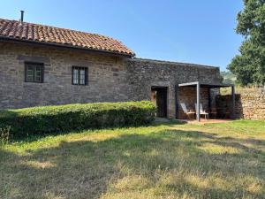 an old stone house with a table and a porch at Casita Madernia in Molledo