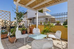 a patio with a table and chairs on a balcony at Appartamento Venere in villa 15pax in Marina di Ragusa