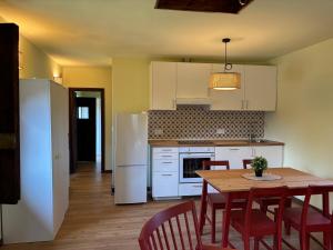a kitchen with a table and chairs and a white refrigerator at Casita Madernia in Molledo +8 photos