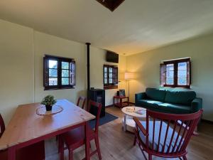 a living room with a table and a green couch at Casita Madernia in Molledo