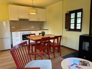 a kitchen with a wooden table and chairs and a kitchen with white cabinets at Casita Madernia in Molledo