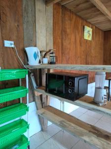 a microwave sitting on a shelf in a kitchen at Cabaña Cherenga in Sarchí +23 photos