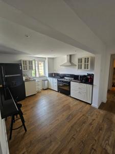 a kitchen with white cabinets and a wooden floor at Luca apartament 3 camere in Băile Herculane