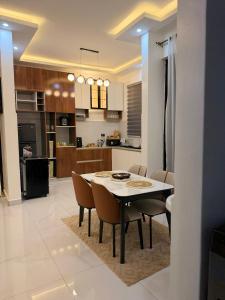 a kitchen and dining room with a table and chairs at Abban homes in Kampala +3 photos