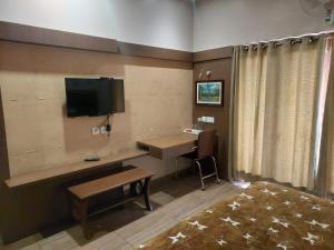 a room with a desk and a tv on the wall at Hotel Dreamland in Kodaikānāl
