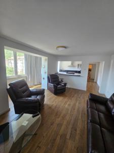 a living room with two leather chairs and a table at Luca apartament 3 camere in Băile Herculane +6 photos