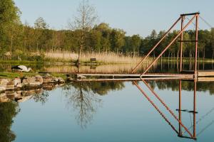 a bridge over a body of water with a bird at Herrmanns-hof in Kronowo +1 photo