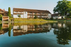 a house sitting next to a body of water at Herrmanns-hof in Kronowo