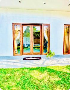 a window of a house with a mat in the grass at Villa Lithu in Weligama
