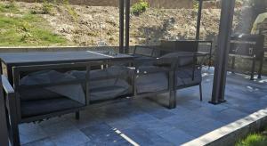 a black table and chairs sitting under a building at E&T-Cabin A frame in Sibiu