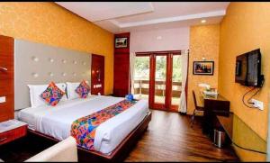 a bedroom with a large bed and a television at Hotel Dreamland in Kodaikānāl