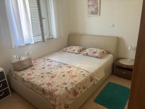 a small bedroom with a bed with two pillows at Apartman Igor in Čižići +17 photos