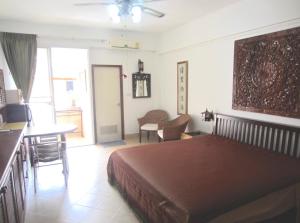 1 dormitorio con 1 cama, mesa y sillas en DAO Studio Apartments, en Patong Beach