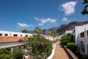 a street in positano with mountains in the background at Ona Las Rosas in Puerto de Santiago
