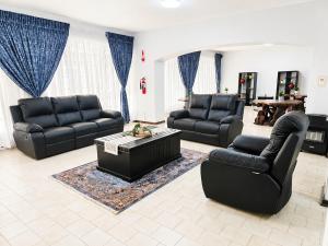 a living room with two black couches and a coffee table at Cleopatra Palace in Vereeniging