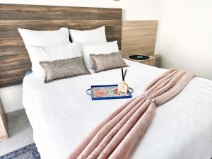a bedroom with a large white bed with long pillows at Cleopatra Palace in Vereeniging