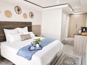 a bedroom with a large white bed with a blue blanket at Cleopatra Palace in Vereeniging