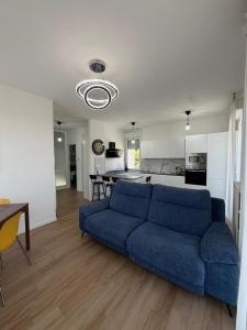 a living room with a blue couch and a kitchen at Bed And Breakfast Castello7 in San Felice del Benaco