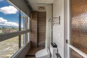 a bathroom with a toilet and a shower with a window at 聽風會館 in Yuanshan +50 photos
